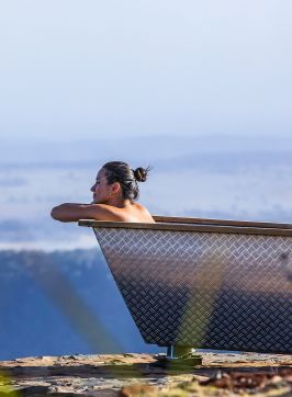 Woman enjoying Bubbletent Australia's outdoor bathtub with scenic views over, Capertee Valley