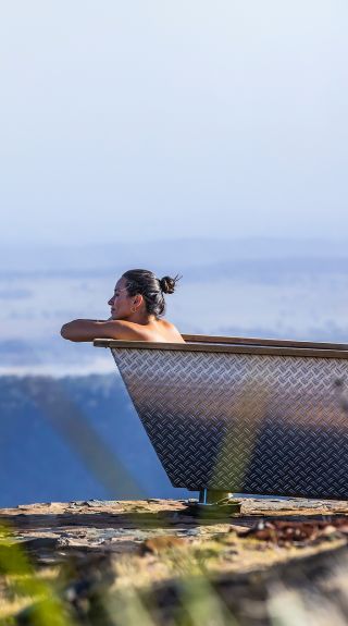 Woman enjoying Bubbletent Australia's outdoor bathtub with scenic views, Capertee Valley