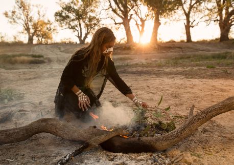 Young girl from the Barkindji nation preparing leaves for a smoking ceremony in Wilcannia