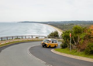 Students in campervan driving towards Cape Byron Lighthouse, Byron Bay