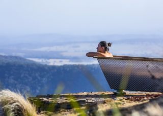 Woman enjoying Bubbletent Australia's outdoor bathtub with scenic views, Capertee Valley