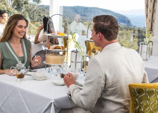 Couple enjoying a premium afternoon high tea at the Wintergarden restaurant within The Hydro Majestic Hotel, Medlow Bath