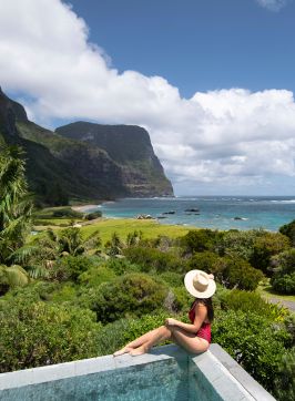 Woman enjoying view by the pool at Capella Lodge, Lord Howe Island