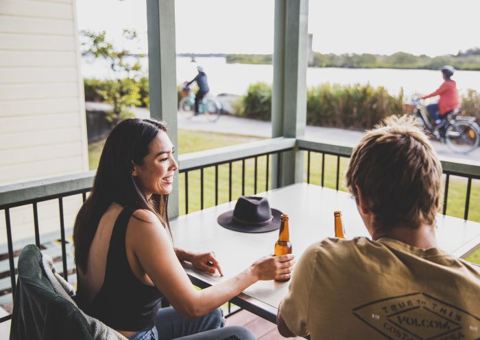 Couple enjoying scenic views from their waterfront villa at Calypso Yamba Holiday Park in Yamba, Clarence Valley