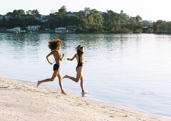 Friends heading for a swim at Naru Beach, Lake Macquarie, North Coast