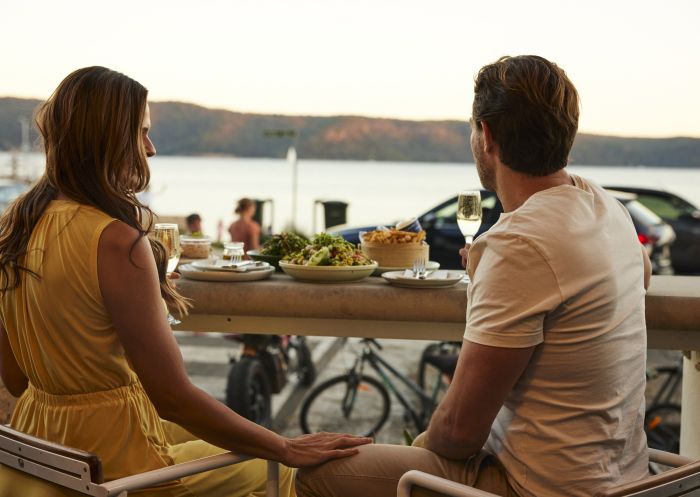 Couple enjoying food and drink at The Boathouse Hotel Patonga, Patonga 