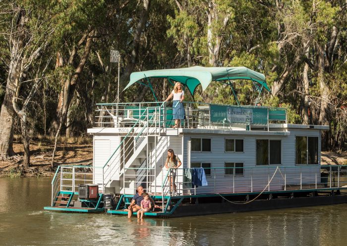 Family enjoying the scenic Edward River from their Edward River Houseboats vessel, Deniliquin