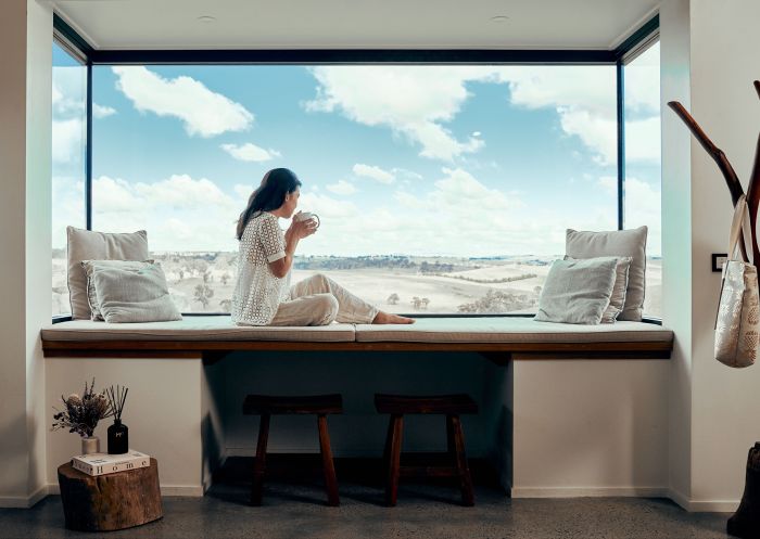 Woman enjoying the view from the window at Wilga Station, Evans Plains