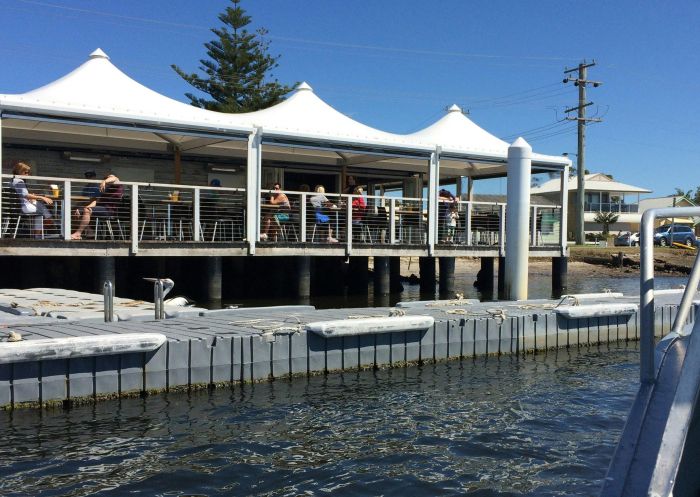 Outdoor dining with water views at the Tea Gardens Boatshed, Teagardens