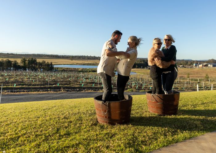 Friends having fun crushing grapes at Hunter Valley Resort, Pokolbin