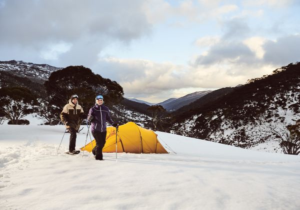 A couple snowshoeing by their campsite through Dead Horse Gap, Thredbo in the Snowy Mountains