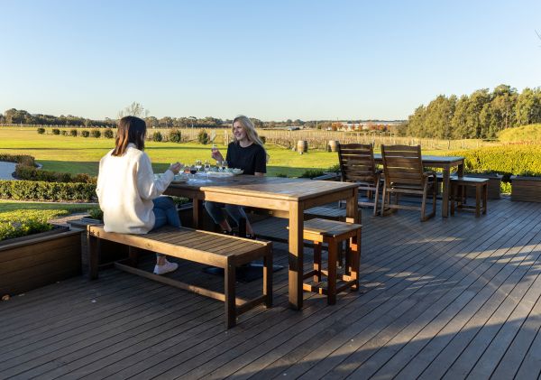 Friends enjoying wine outdoors at Peterson House, Pokolbin