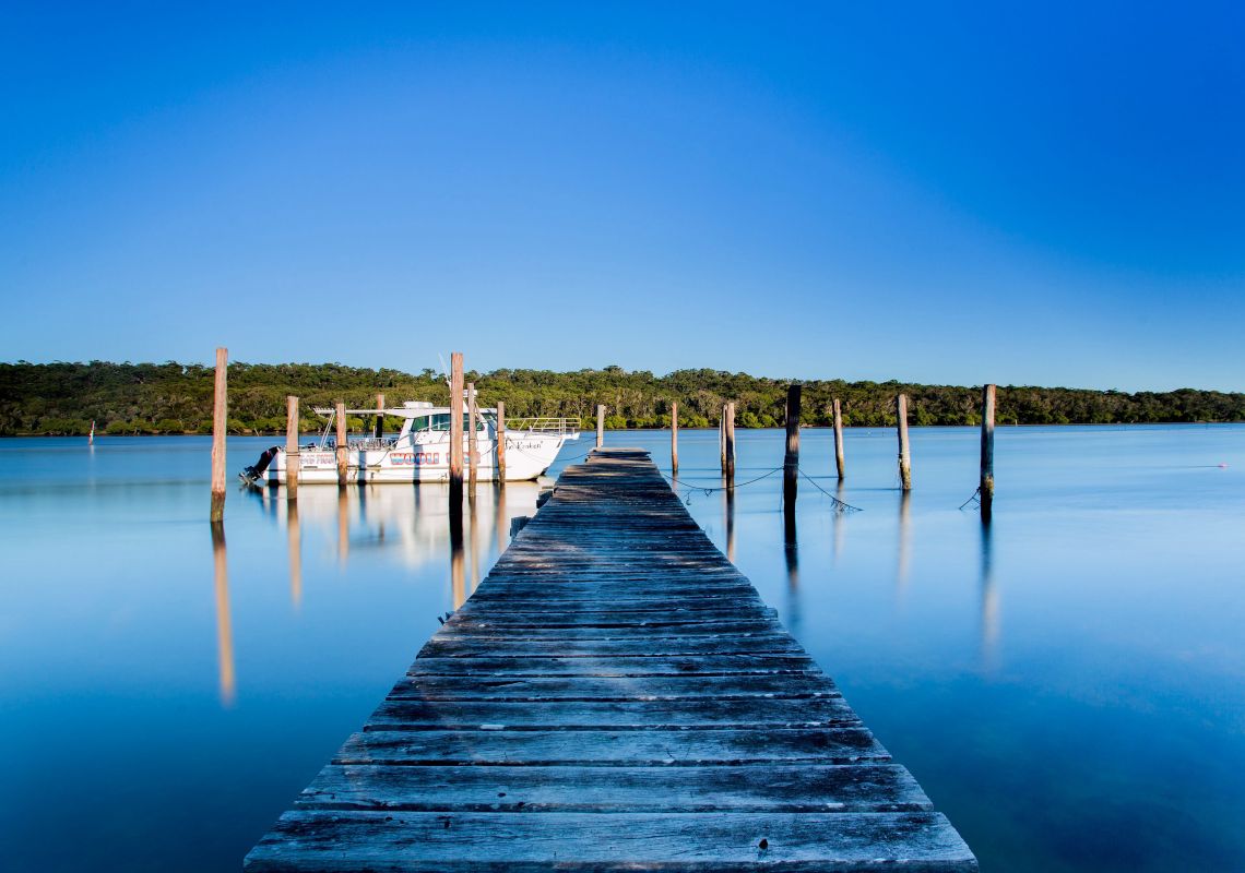 Boat moored at the end of the pier on Wooli Wooli River, Wooli