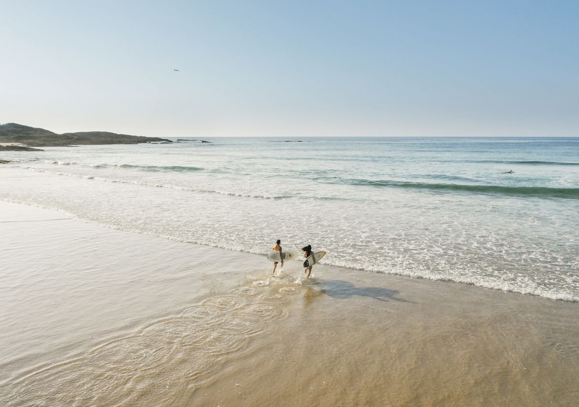 Couple enjoying a morning surf at Birubi Beach, Port Stephens