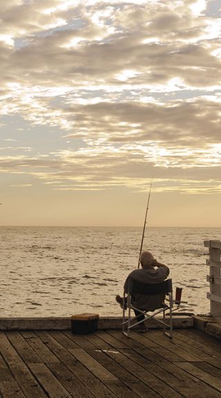 Man enjoying a relaxing day fishing off Tathra Wharf