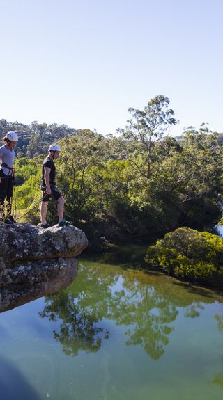 Couple ready to abseil off a clifftop in the Shoalhaven region near Nowra