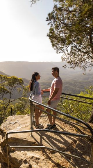 Couple enjoying views overlooking the Jamison Valley along the Giant Stairway Walking Track, Katoomba