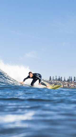 Surfer catching a wave off Werri Beach, south of Kiama on the South Coast