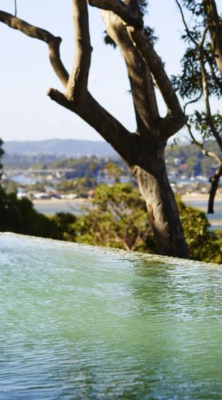 Woman relaxing in the pool at Pretty Beach House, Pretty Beach - Credit: Anson Smart