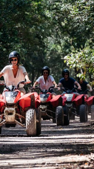 Friends enjoying a guided tour on quad bikes at Glenworth Valley in the Central Coast