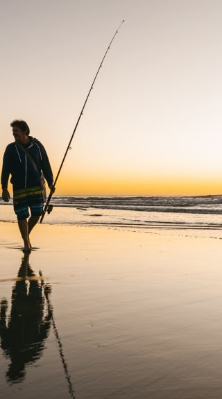 Fisherman walking along Iluka Beach in Iluka, Clarence Valley - Credit: My Clarence Valley