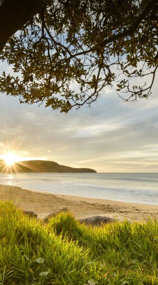 Sun rises over the horizon at Killcare Beach, Killcare in Central Coast