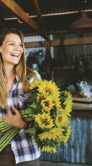 Woman with a bunch of sunflowers at The Farm, Byron Bay