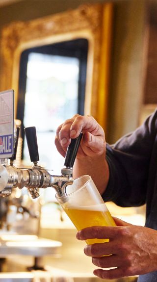 Man pouring a beer at the Argyle Inn, Taralga