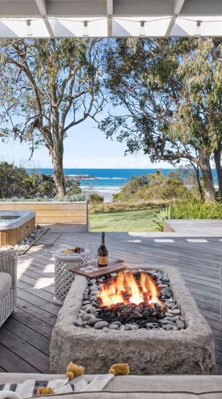 Outdoor seating with fire pit and lounge chairs at Barellen Beach House, Coffs Harbour