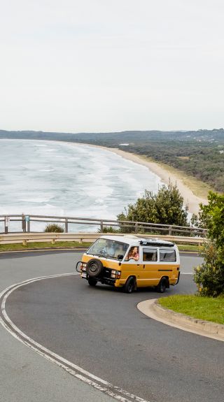 Students in campervan driving towards Cape Byron Lighthouse, Byron Bay