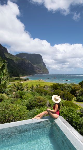 Woman relaxing by the pool at Capella Lodge, Lord Howe Island