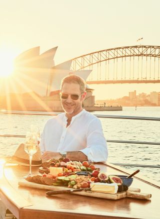 Man enjoying grazing plate on Ghost 2 Super yacht, Sydney Harbour