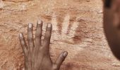 Mutawintji National Park tour guide Keanu Bates showing visitors Aboriginal rock art at Mutawintji Historic Site, Outback NSW