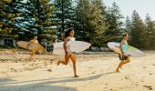 Friends running towards the surf at NRMA Murramarang Beachfront Holiday Resort, South Durras